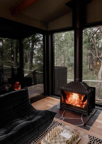 a fireplace in the living room of a house at 'Sisters' - Cliff top cabin with hot tub in Spring Beach