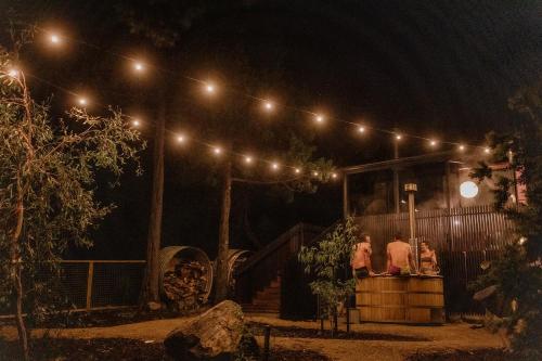 two people standing on a stage at night at 'Sisters' - Cliff top cabin with hot tub in Spring Beach