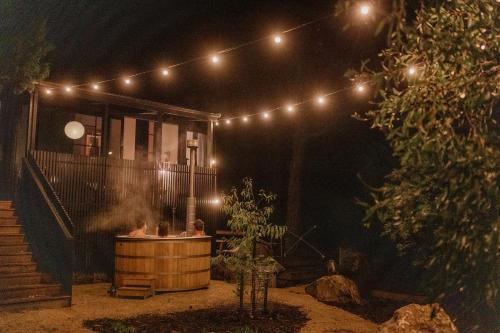 a night shot of a hot tub with lights at 'Sisters' - Cliff top cabin with hot tub in Spring Beach