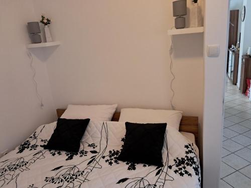 a bedroom with a bed with black pillows on it at Apartment Pamela in Gajac