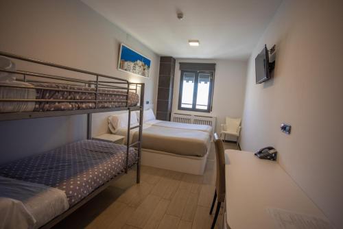 a small room with two bunk beds and a desk at Hotel LB Villa De Cuenca in Cuenca