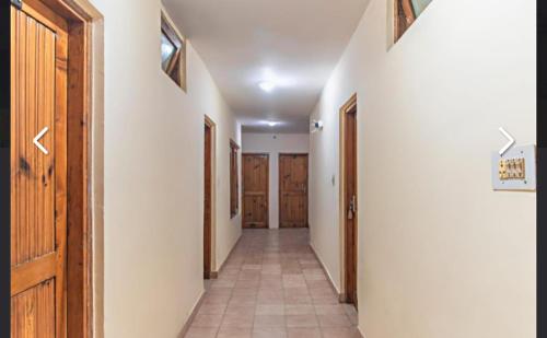 a hallway with wooden doors and a tile floor at Hotel Prince in Manāli