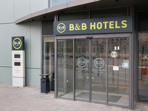 a building with a bbb hotels sign and revolving doors at B&B Hotel Berlin City-West in Berlin