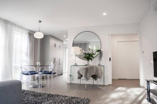 a living room with a table and chairs and a mirror at Restful stay on Geraldine Street Suburban Beauty in Christchurch