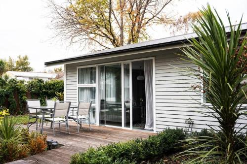 a house with a deck with chairs and a table at Restful stay on Geraldine Street Suburban Beauty in Christchurch