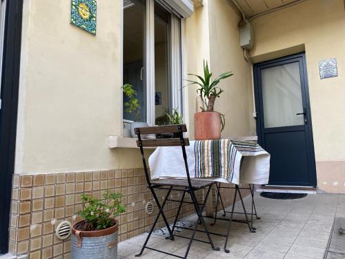 une chaise assise sur la terrasse couverte d'une maison dans l'établissement Charmant studio avec extérieur Paris 13, à Paris