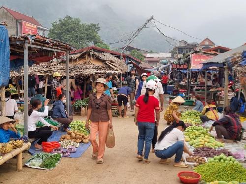 a group of people walking through an open market at Inh La Home Pu Luong in Pu Luong