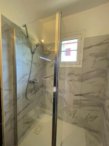 une douche avec une porte vitrée dans une salle de bain dans l'établissement Charmante Maison Basque - 15min à pieds des plages - 6 Personnes, à Guéthary