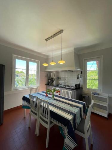 une cuisine avec une table et des chaises dans une pièce dans l'établissement Charmante Maison Basque - 15min à pieds des plages - 6 Personnes, à Guéthary