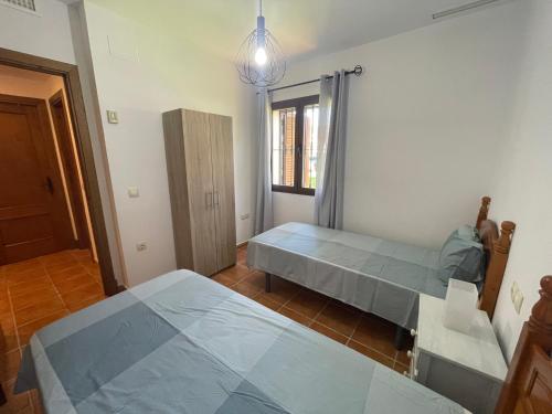a bedroom with two beds and a window at Chalet Urb Doña Violeta 500m Mar in Chiclana de la Frontera