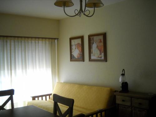 a living room with a yellow couch and a window at Apartamento Del Mar in Mar del Plata