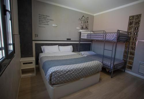 a bedroom with a bed and two bunk beds at Hotel LB Villa De Cuenca in Cuenca