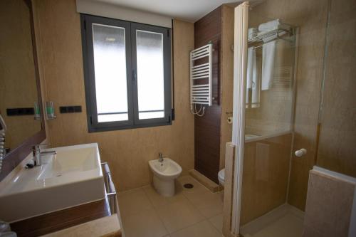 a bathroom with a sink and a toilet and a shower at Hotel LB Villa De Cuenca in Cuenca