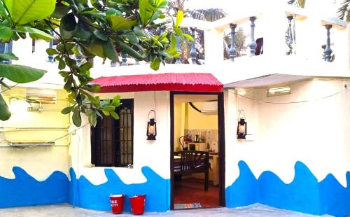 ein Haus mit farbenfroher Vordertür mit roter Markise in der Unterkunft Chan Beach Resort & Hotel in Bahūr