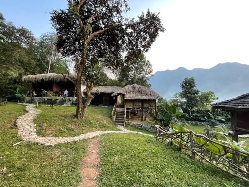 een hut met een boom en een onverharde weg bij Palm Hill Chalet in Ha Giang