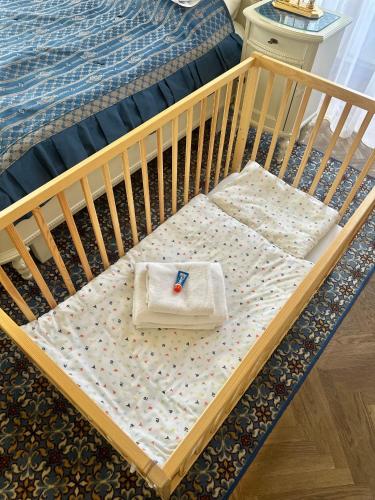 a crib with a pair of scissors on the bed at Château Liblice in Byšice