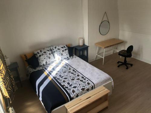 une chambre avec un lit, un bureau et une chaise dans l'établissement Le jardin d'Alfortville, à Alfortville