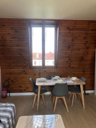 un salon avec une table, des chaises et un canapé dans l'établissement Le jardin d'Alfortville, à Alfortville