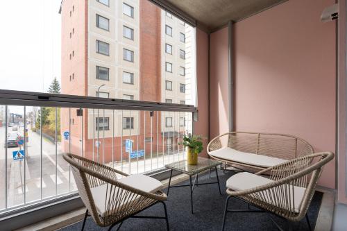 a balcony with two chairs and a table and a window at Isla Homes - Stadion, Supermarket & Alko in Tampere