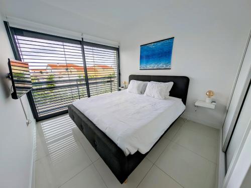 a bedroom with a large bed and a window at Apartamentos Aurea - Porto Santo in Porto Santo