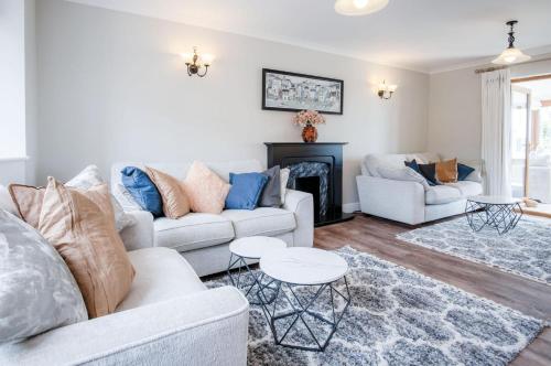 a living room with two couches and a fireplace at Highfield - 5 Bedroom Holiday Home - Pembroke Dock in Pembroke Dock