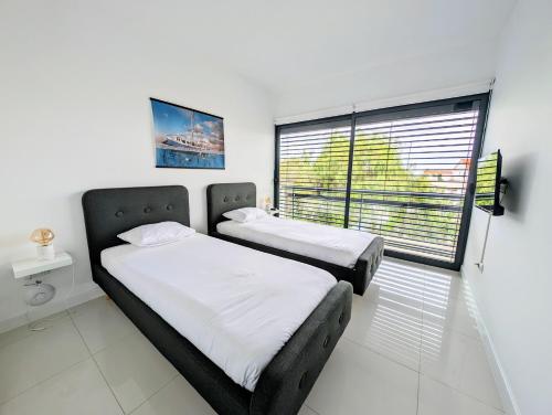 two beds in a room with a window at Apartamentos Aurea - Porto Santo in Porto Santo
