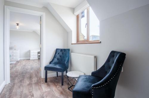 two blue chairs and a table in a room at Highfield - 5 Bedroom Holiday Home - Pembroke Dock in Pembroke Dock