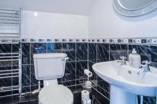 a bathroom with a toilet and a sink at Highfield - 5 Bedroom Holiday Home - Pembroke Dock in Pembroke Dock