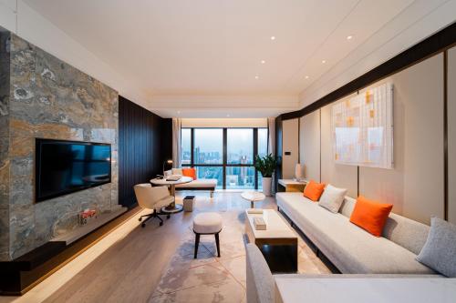 ein Wohnzimmer mit einem Sofa und einem TV in der Unterkunft Crowne Plaza Shenzhen Nanshan, an IHG Hotel in Shenzhen