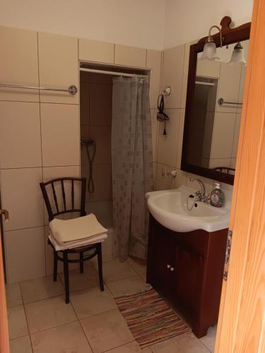 a bathroom with a sink and a shower and a chair at Guest House Lucijo in Vrboska