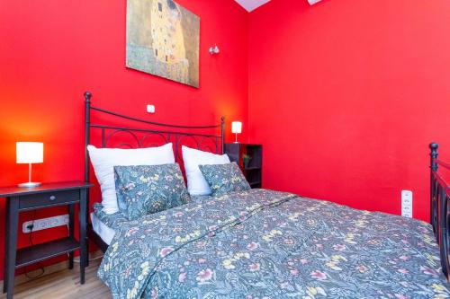 1 dormitorio rojo con 1 cama y pared roja en Badepest Apartment Budapest, en Budapest