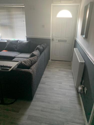 a living room with a couch next to a door at 1 bed fully furnished Walsall property in Walsall