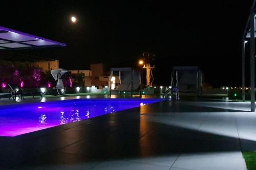 an empty swimming pool at night with purple lights at Nina Apartment in Chania Town