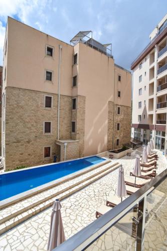 ein Schwimmbad mit Liegestühlen und ein Gebäude in der Unterkunft Dolami residence in Becici