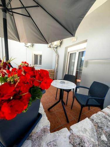 a room with a table and a vase with red flowers at Nina Apartment in Chania Town
