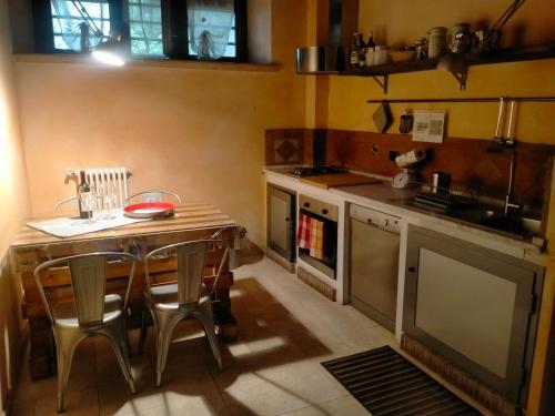 una pequeña cocina con mesa de madera y sillas en AL LOFT, Centro Storico en Prato
