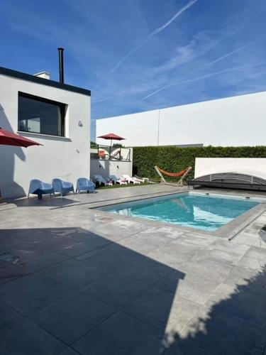 une piscine dans l'arrière-cour d'une maison dans l'établissement Entre Terre et Mer 12 Personnes Espace Piscine chauffée, à Landivisiau