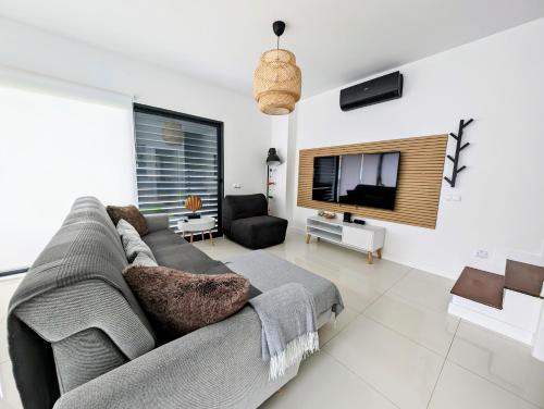 a living room with a couch and a flat screen tv at Apartamentos Aurea - Porto Santo in Porto Santo