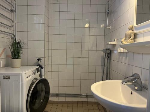 uma casa de banho em azulejos brancos com uma máquina de lavar roupa e um lavatório em Åre Travel - Åre Fjällbyn em Åre