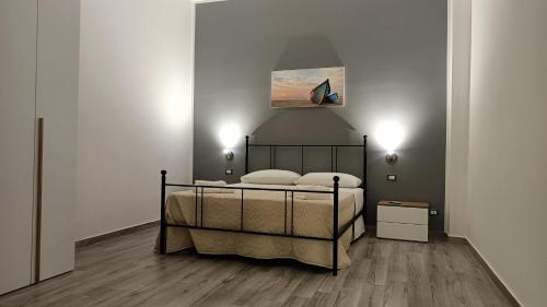 a bedroom with a bed and a painting on the wall at Il tramonto in Balestrate