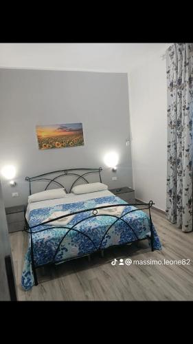 a bedroom with a bed and a painting on the wall at Il tramonto in Balestrate