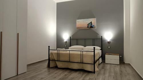 a bedroom with a bed and a painting on the wall at Il tramonto in Balestrate