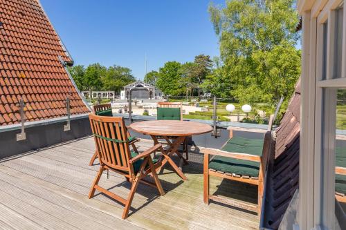 a patio with a wooden table and chairs on a deck at Ferienwohnung "Blaues Haus" in Boltenhagen