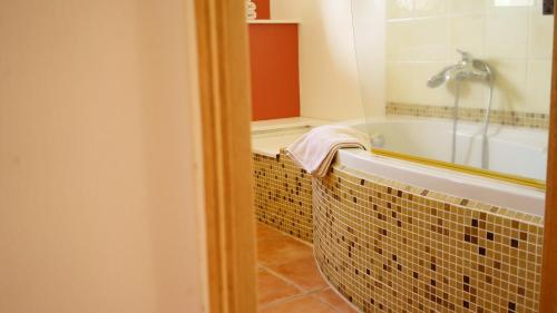 une salle de bain avec une baignoire et un lavabo dans l'établissement Chambres d'hôtes, B&B La Musardière, à Alba-la-Romaine
