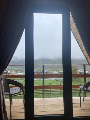 a view from a window of a balcony with chairs at AURA Cottages in Stepantsminda