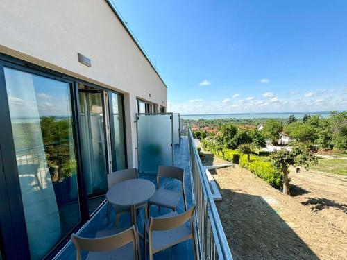 a balcony with a table and chairs on it at Zenit Wellness Hotel Balaton in Vonyarcvashegy