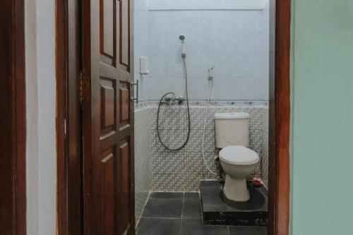 a bathroom with a toilet and a shower at Glory Homestay in Yogyakarta