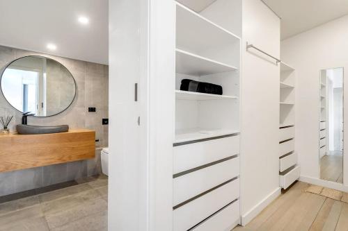 a bathroom with white cabinets and a mirror at Picture-Perfect Masterpiece In Exclusive Mosman in Sydney