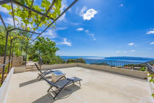 a patio with two chairs and a view of the ocean at Holiday home Tranquillo in Makarska