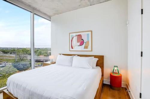 a bedroom with a white bed and a large window at Luxury Oasis on Rainy Street in Austin